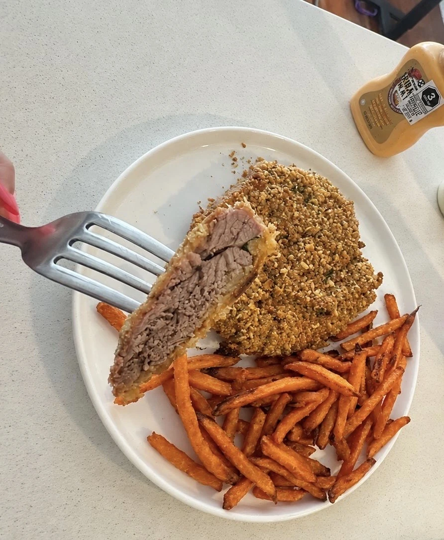 Fotografía original: milanesa servida con guarnición y un bocado en el tenedor
