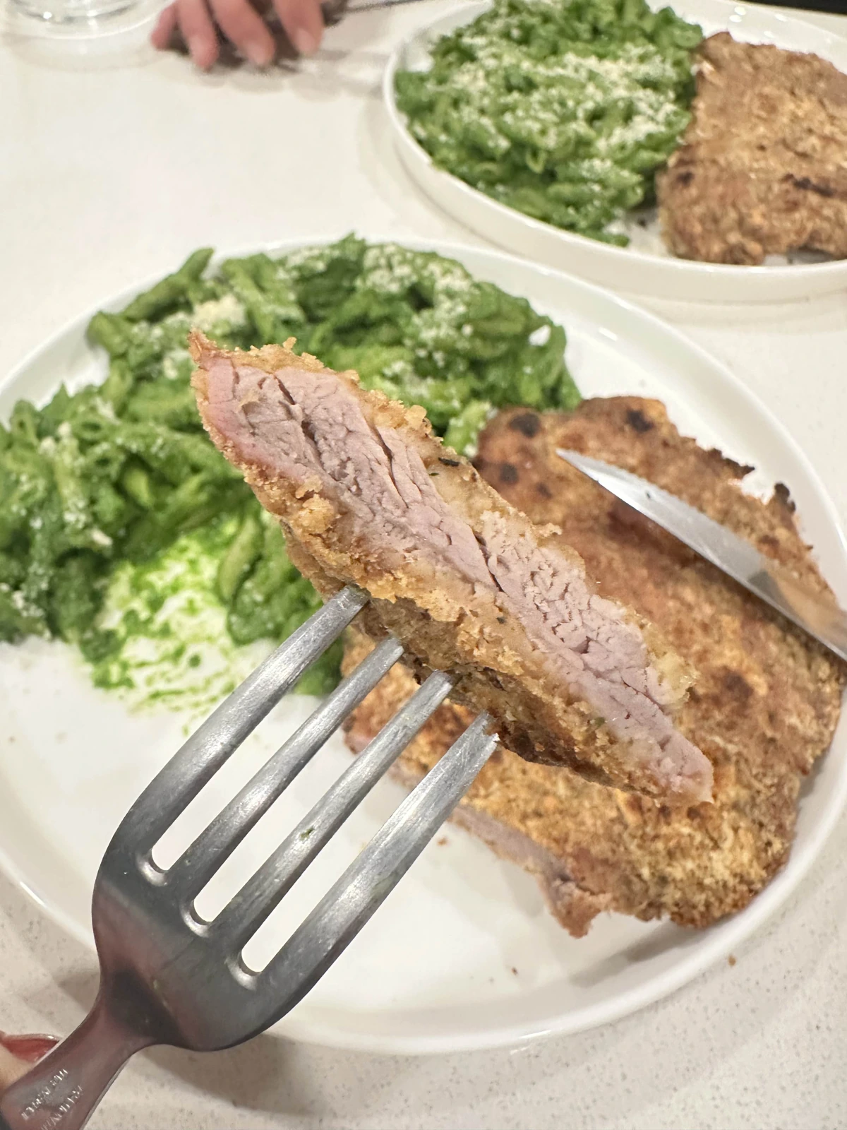 Fotografía original completa de la milanesa cortada, con ensalada, en la mesa